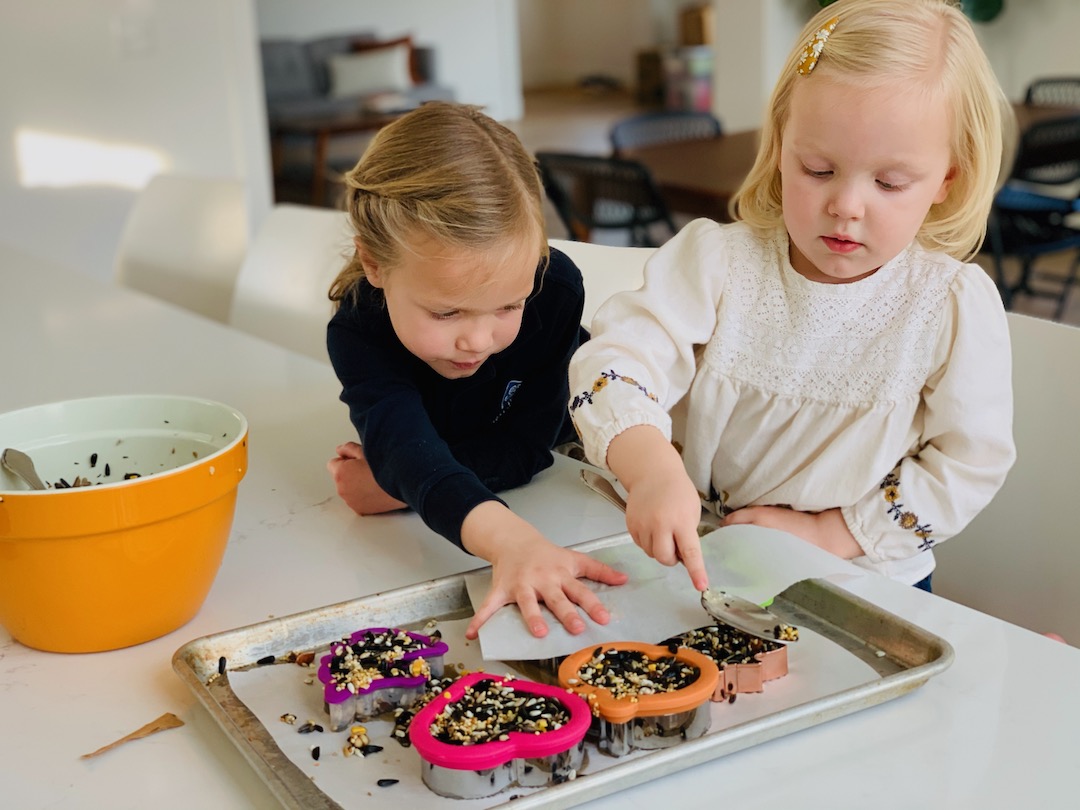 pressing birdseed into cookie cutters