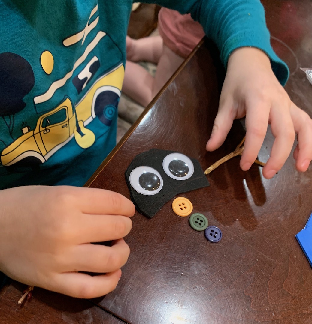 child building a freezy the snowman with google eyes and buttons