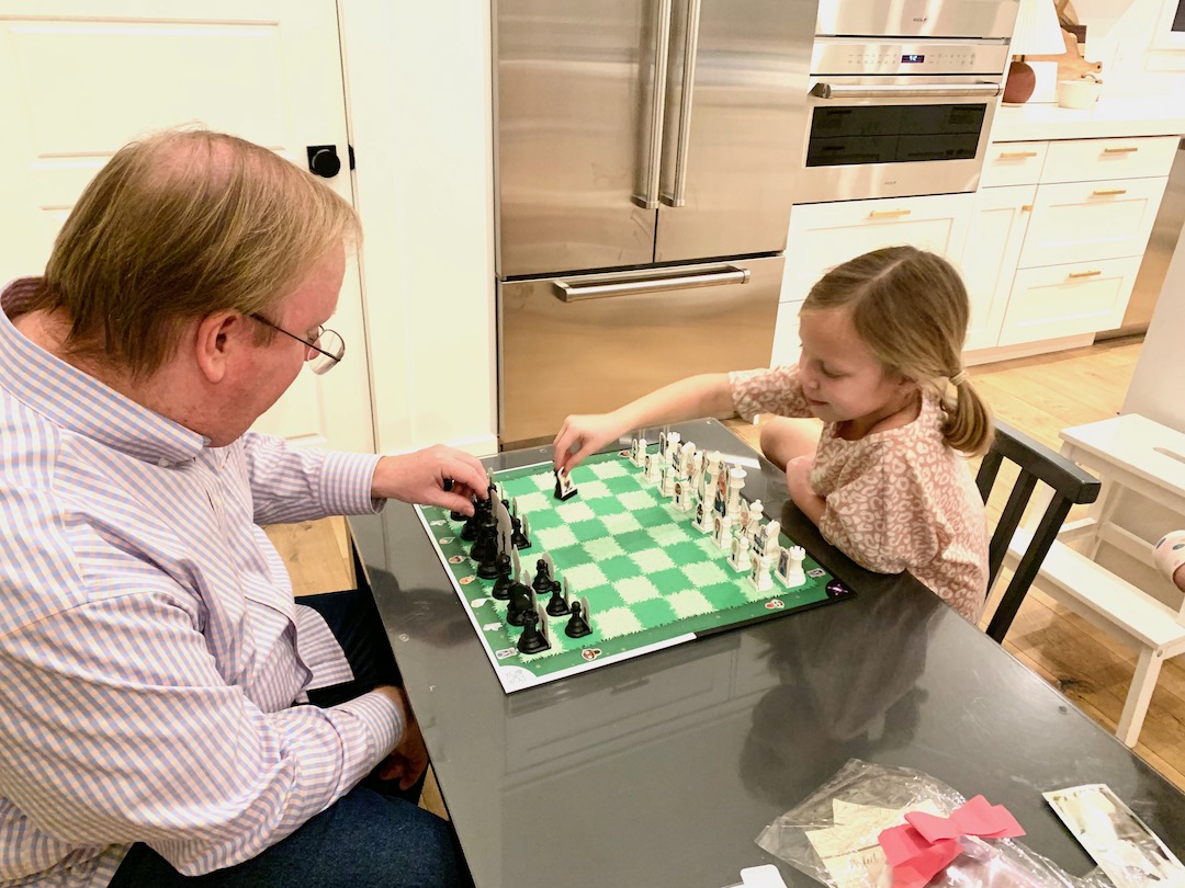 Storytime Chess Game with grandfather and granddaughter