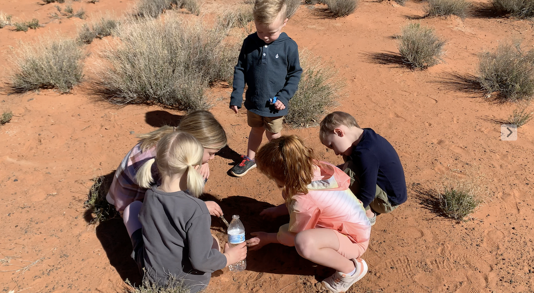 children playing in red desert sand