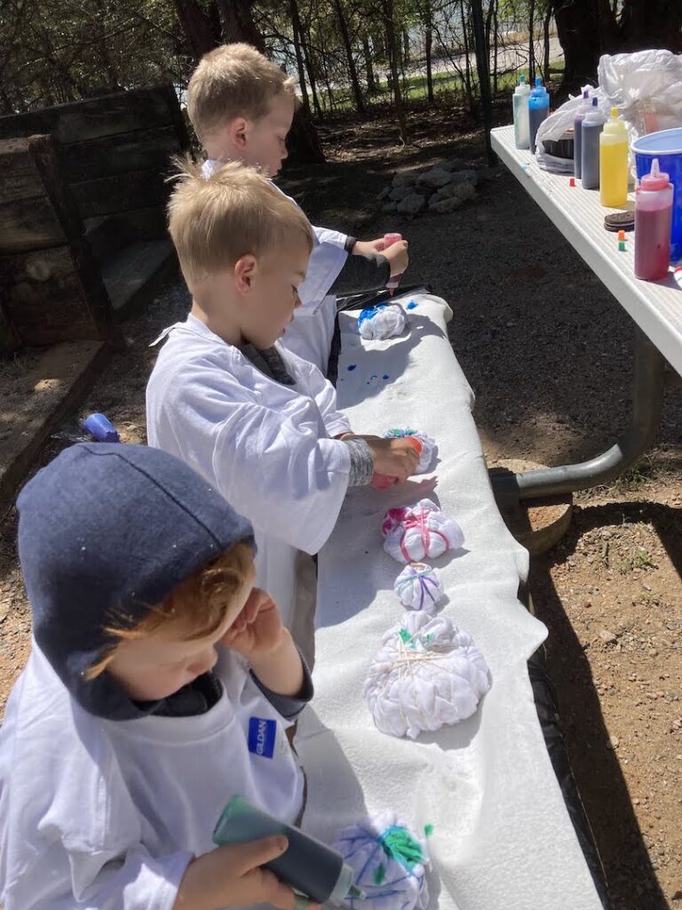 children tie-dying t-shirts at campout