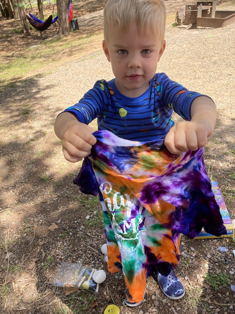 child holding tie-dyed t-shirt